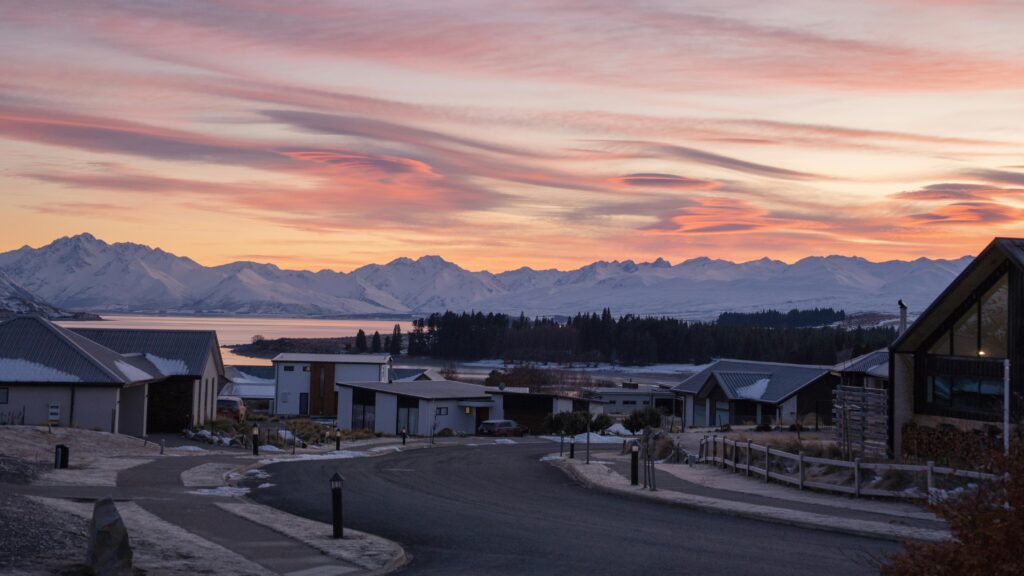 Beautiful sunrise over a suburban area in Canterbury, New Zealand, with a snowy mountain backdrop.