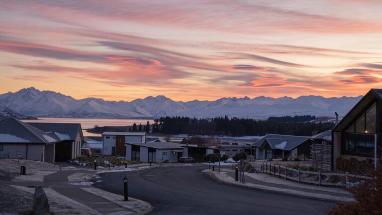 Beautiful sunrise over a suburban area in Canterbury, New Zealand, with a snowy mountain backdrop.
